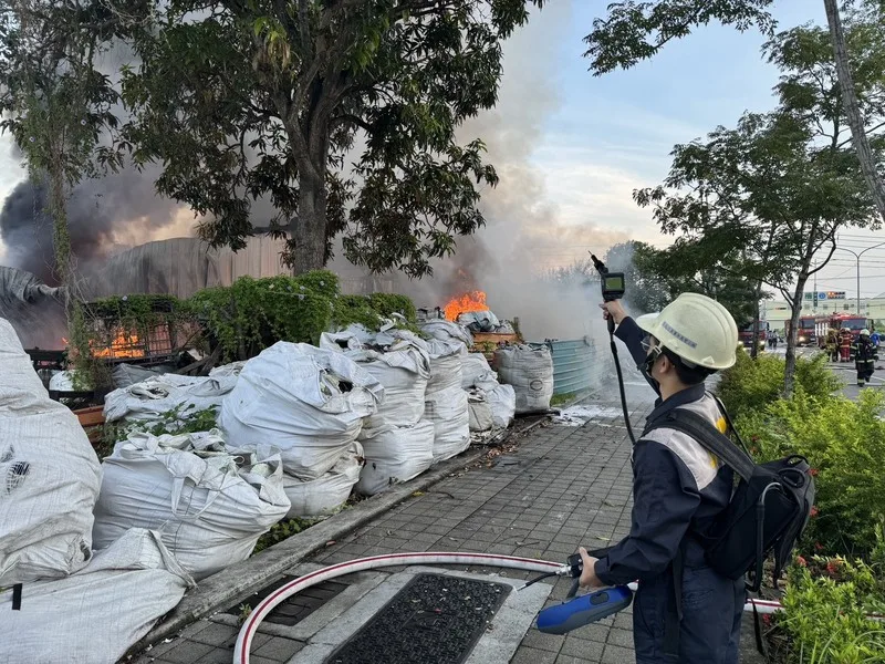 高雄岡山區一間資源回收廠堆置塑膠今天清晨起火，經消防員布水線灌救已撲滅火勢。（高雄市環保局提供）