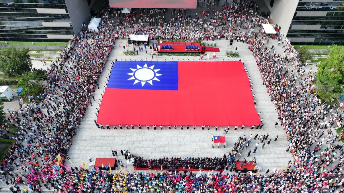 ▲76位民防義警及霹靂小組聯手展護全國最大長36公尺、寬24公尺的巨幅國旗進場，場面吸睛壯觀。(圖/中市府提供)