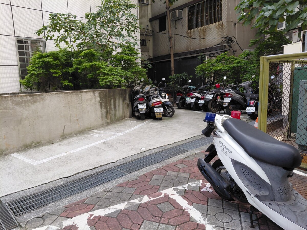 新北三重警分局三重派出所旁的停車區雜亂不堪，更有疑似查扣的未懸掛車牌的機車雜亂停放。(影像由記者郭晉嘉拍攝)。