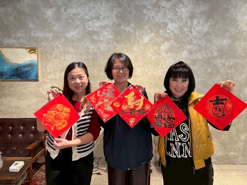 移民署嘉義市服務站黃艶主任（中）為讓新住民感受年節溫暖氛圍，邀新住民們一起以馬年為靈感，揮毫創意春聯迎新春，並防詐騙等政令宣導，陪伴新住民安心過好年。（圖/移民署提供）