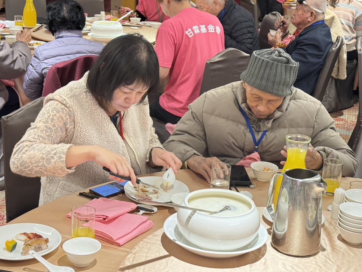 ▲長輩提前圍爐迎新春，志工幫長輩剪碎食物。(圖/中市府提供)