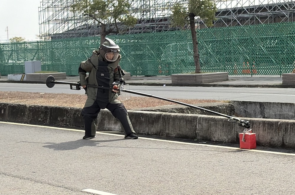 防爆專業人員以機械手臂夾取爆裂物。（圖/記者黃采琳翻攝）