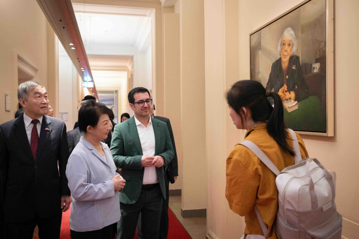 ▲柏林邦議會友台小組共同主席Jian Omar 議員導覽議會並介紹牆上掛有榮譽市民畫像。(圖/中市府提供)